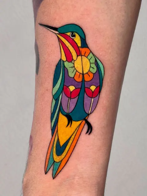 Colibrí geométrico a color en el antebrazo