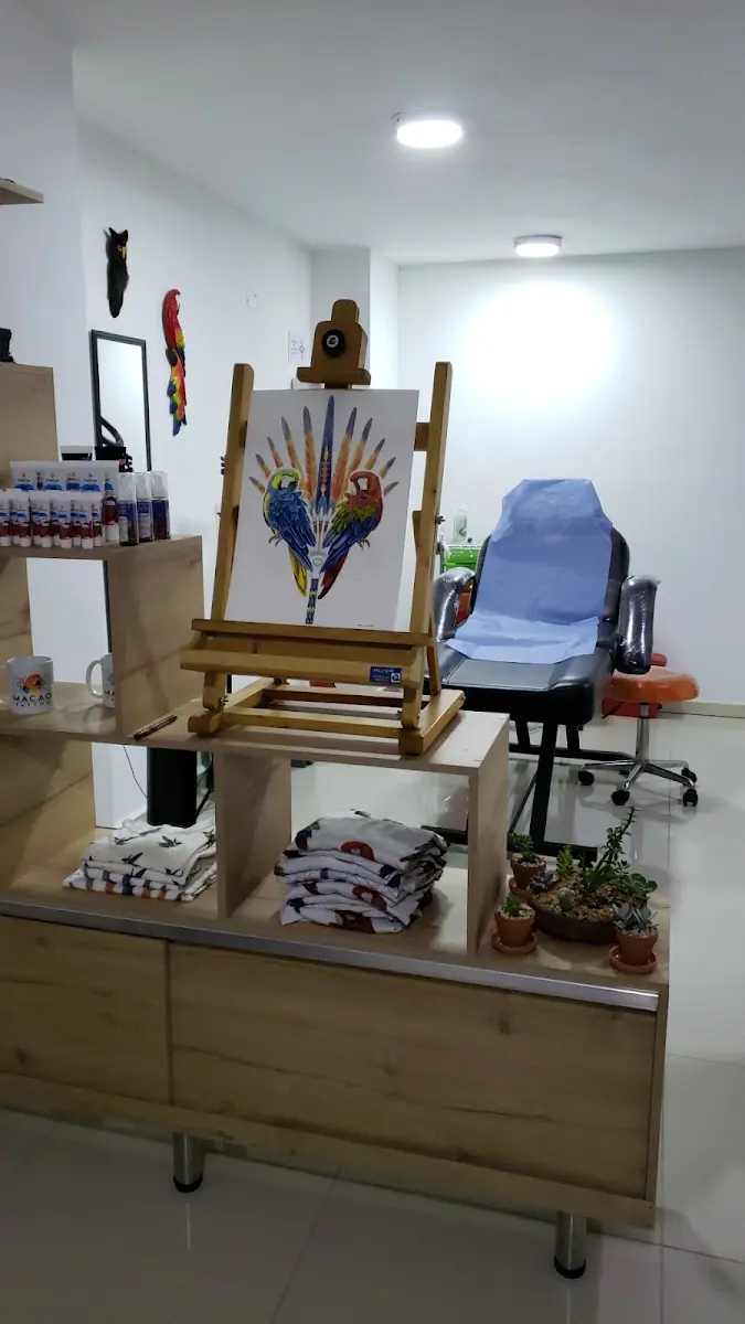 Estudio privado Macao Tattoo con camilla, caballete con un diseño de ave y repisa